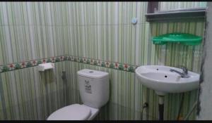 a bathroom with a toilet and a sink at Ruteng YosPrima Garden in Lao +8 photos