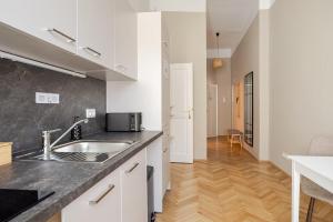 a kitchen with a sink and a counter top at Boho Living Altstadt Suites - Free Parking by HERO HOMES Graz in Graz