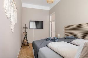 a bedroom with two beds and a flat screen tv at Boho Living Altstadt Suites - Free Parking by HERO HOMES Graz in Graz