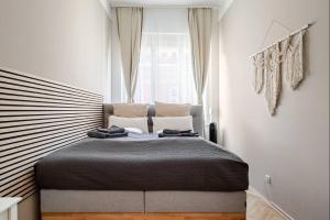 a bedroom with a large bed in front of a window at Boho Living Altstadt Suites - Free Parking by HERO HOMES Graz in Graz +78 photos