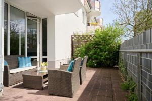 a patio with wicker chairs and a table at Ferienwohnung Bootsteg Moba-Travel in Priwall