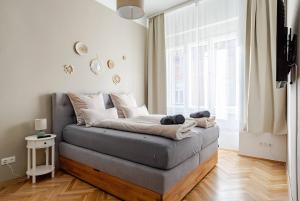 a couch in a living room with a large window at Boho Living Altstadt Suites - Free Parking by HERO HOMES Graz in Graz