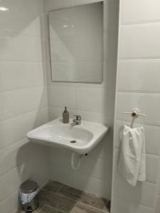 a white bathroom with a sink and a mirror at Hostal Camino micológico in Navaleno