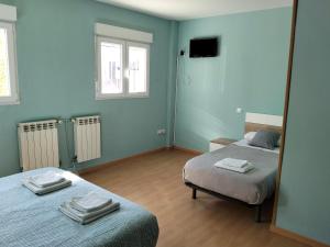 a bedroom with two beds and a mirror at Hostal Camino micológico in Navaleno