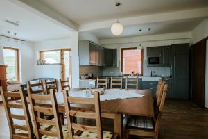 a kitchen with a wooden table and a dining room at Kavalliera Pensiune in Cotormani