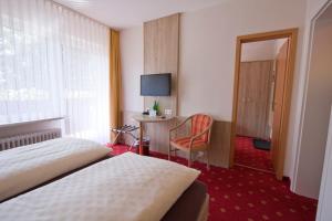 ein Hotelzimmer mit zwei Betten und einem Schreibtisch in der Unterkunft Mein Vierjahreszeiten Hotel Garni Superior in Sankt Andreasberg + 37 Fotos