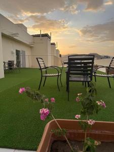 a group of chairs sitting on a lawn with flowers at فـالـي ريزيدنـس - Valley Residence in Al Baha