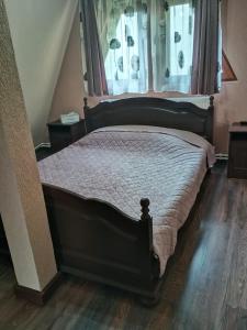 a bedroom with a bed with a window and wooden floors at Cabana Taia in Petrila
