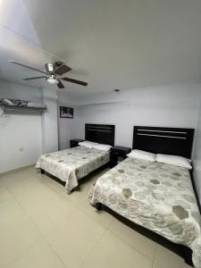 a bedroom with two beds and a ceiling fan at Camino de la Plata Hotel in Fresnillo de González Echeverría