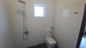 a white bathroom with a shower and a toilet at The Reef Edge in Matara +75 photos