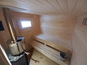 an inside view of a wooden sauna with a tub at Kaltenes Liepziedi in Roja +18 photos