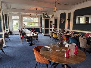 a restaurant with tables and chairs and people sitting at tables at Les 3 rois by YY in Villers-Bocage