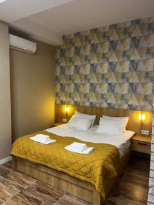 a bedroom with a large bed with towels on it at Seven Rooms Hotel in Tbilisi City