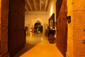 a hallway of a building with a table in the distance at Hotel Noi 1860 Cartagena in Cartagena de Indias
