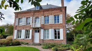 an old brick house with white windows and a porch at La Charmeraie d'Aumâtre in Aumâtre