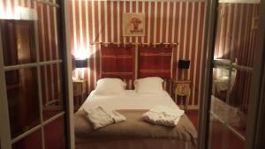 Germigny-lʼEvêqueにあるLOGIS - Hôtel & Restaurant Le Gonfalonのベッドルーム1室(ベッド1台、タオル2枚付)