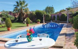 a table with a vase of flowers on it next to a pool at Villa Rocio in Setenil