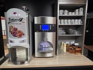 a kitchen with a coffee machine on a counter at Hôtel Restaurant Campanile Aurillac in Aurillac