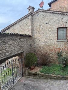 an old brick building with a gate in front of it at Residenza Il Castello Tre in CastellʼArquato
