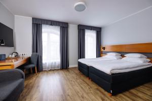 a hotel room with a bed and a desk at Hestia Hotel Ilmarine in Tallinn +28 photos