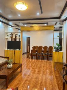 a living room with a table and chairs and a flat screen tv at Bayakyak Soie Residence in General Luna