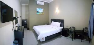 a bedroom with a bed and a flat screen tv at Mata Ie Resort in Sabang