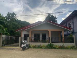 a small house with a scooter parked in front of it at Bayakyak Soie Residence in General Luna