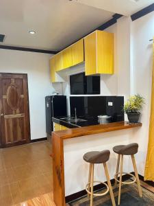 a kitchen with a counter and two stools at Bayakyak Soie Residence in General Luna