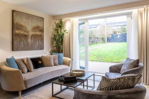 a living room with a couch and two chairs at Arran Shores Luxury Shorefront Garden Terrace Apartment 6 in Lamlash
