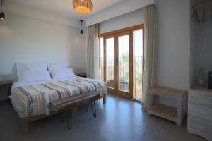 a bedroom with a bed and a large window at Blue Waves Surf House - Anza I in Agadir