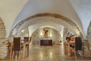 - une salle à manger avec des murs en pierre, des tables et des chaises en bois dans l'établissement Hôtel La Dimora & Spa- Les Collectionneurs, à Oletta