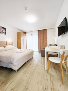 a bedroom with a bed and a table and a desk at Holiday Family Raj pod Sosnami centrum miasta! in Szklarska Poręba
