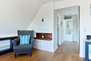 a living room with a chair and a staircase at Ferienwohnung Ostseeperle Moba-Travel in Travemünde