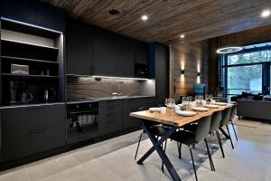 a dining room with a table and a kitchen at Villa Taruilevi 3 inc Hot Tub in Levi