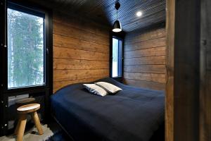 a bedroom with a bed and two pillows on it at Villa Taruilevi 3 inc Hot Tub in Levi