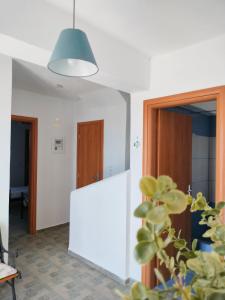 a room with a white wall and a pendant light at Blue Calm House Kythnos in Agios Dimitrios