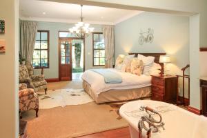 a bedroom with a bed and a bathroom with a tub at New England Cottage by First Private Stays in Underberg