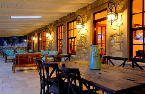 a wooden table in a patio with chairs and a table sidx sidx at New England Cottage by First Private Stays in Underberg