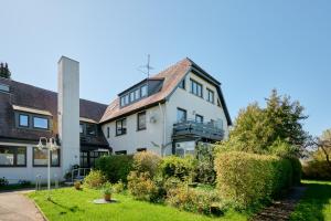 a large white house with a garden in front of it at Ferienwohnung Ostseeperle Moba-Travel in Travemünde