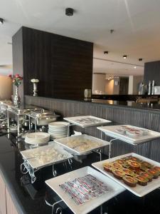 a kitchen with several trays of food on a counter at Hayat Watheer for serviced Apartment in Dammam