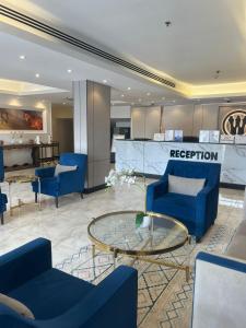 a lobby with blue chairs and a coffee table at Hayat Watheer for serviced Apartment in Dammam +68 photos