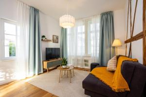 a living room with a couch and a tv at Mariene Home Apartments - Am Hammer in Rösrath