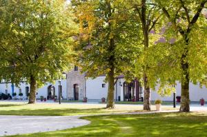 a group of trees in front of a white building at Pałac Łagów - Hotel in Zgorzelec +10 photos