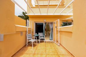 a balcony of a house with a table and chairs at Oasis in Costa Calma
