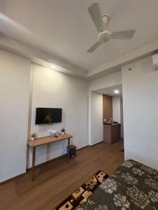 a room with a bed and a tv on the wall at Omaxe Air B&B in Greater Noida