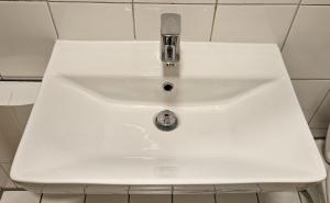 a white sink with a faucet in a bathroom at Wohnung direkt an den Externsteinen in Horn-Bad Meinberg