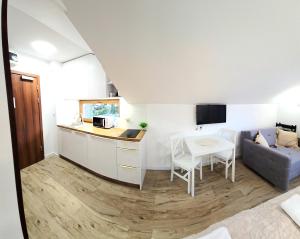 a kitchen and living room with a couch and a table at Holiday Family Raj pod Sosnami centrum miasta! in Szklarska Poręba