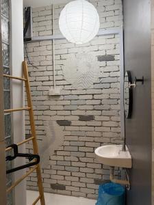 a bathroom with a brick wall and a sink at HuttonSTAY at Georgetown in George Town +45 photos