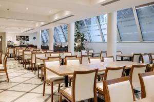 a row of tables and chairs in a restaurant at Hestia Hotel Ilmarine in Tallinn