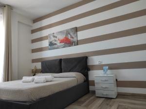 a bedroom with a striped wall with a bed at Hotel Rodi Beach FRONTE SPIAGGIA in Rodi Garganico